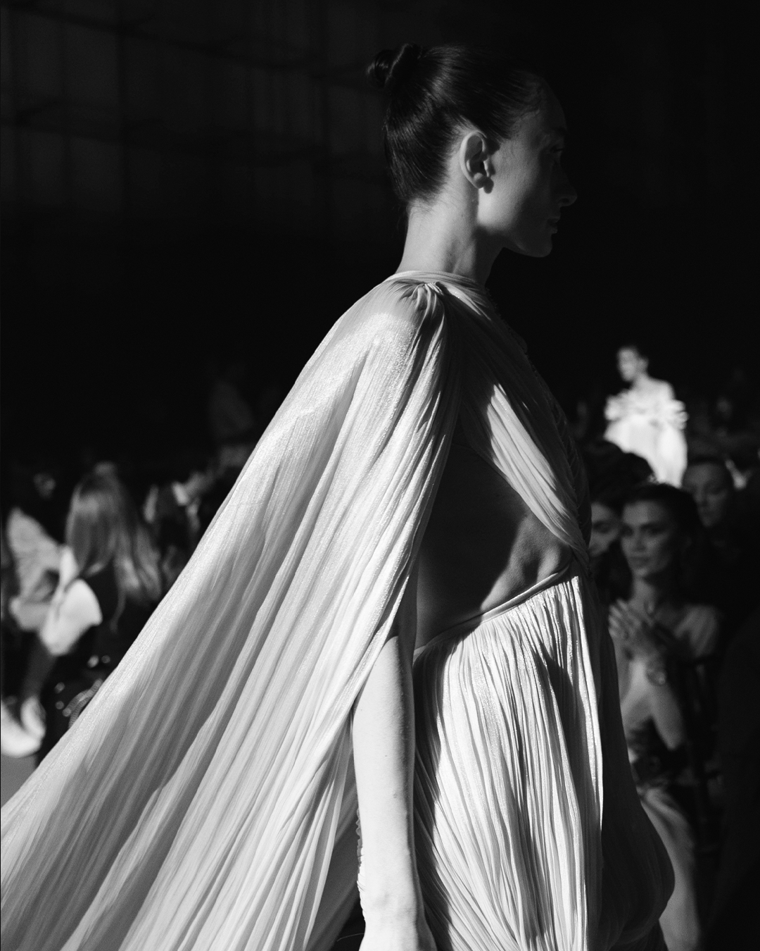 Finely pleated fabric features a high neckline