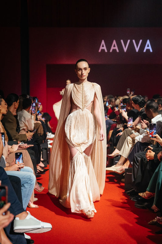 Finely pleated fabric features a high neckline