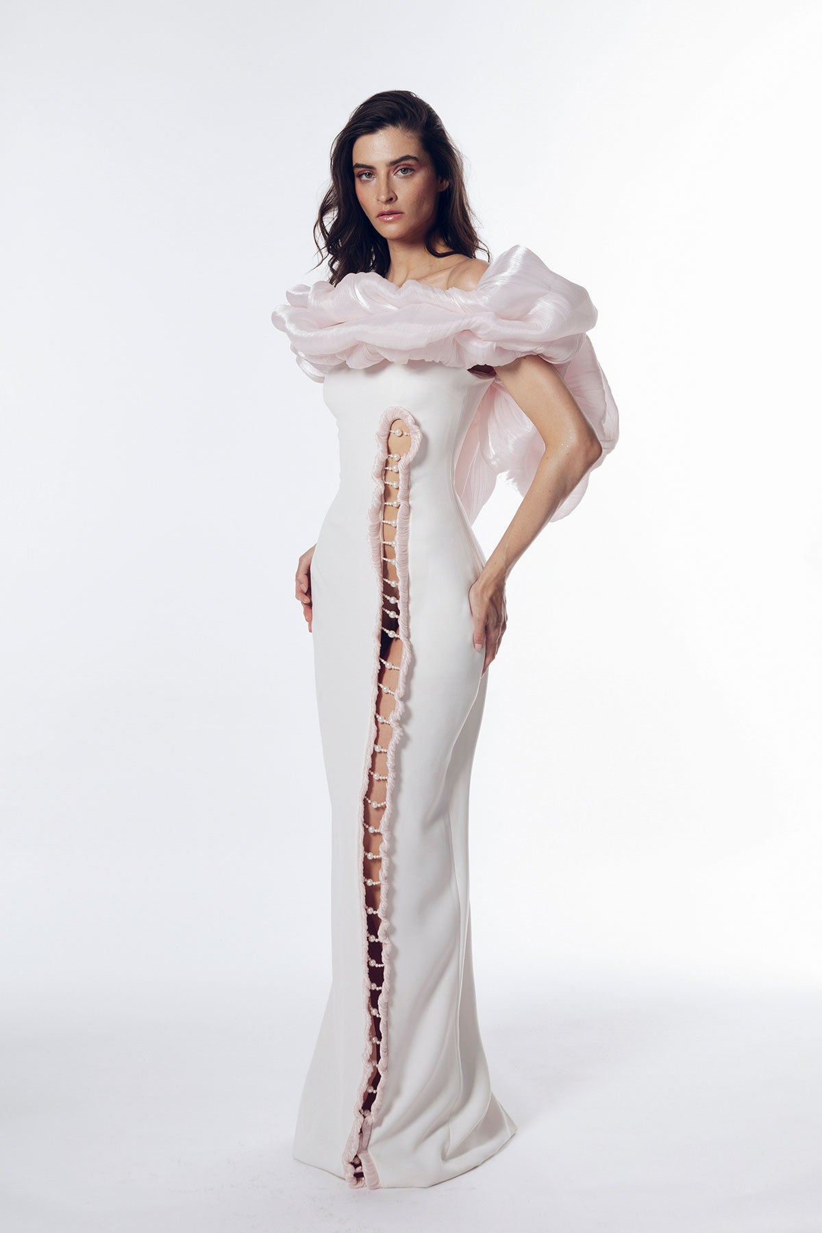 Off-white crepe gown with pearl embellishments placed on the long cutout.