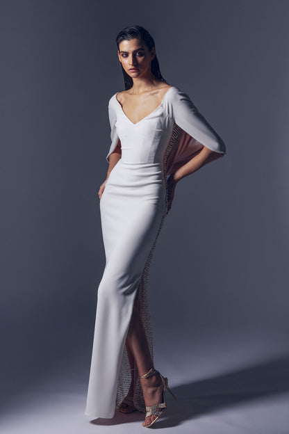 Off-shoulder white crepe dress with a fitted bodice.